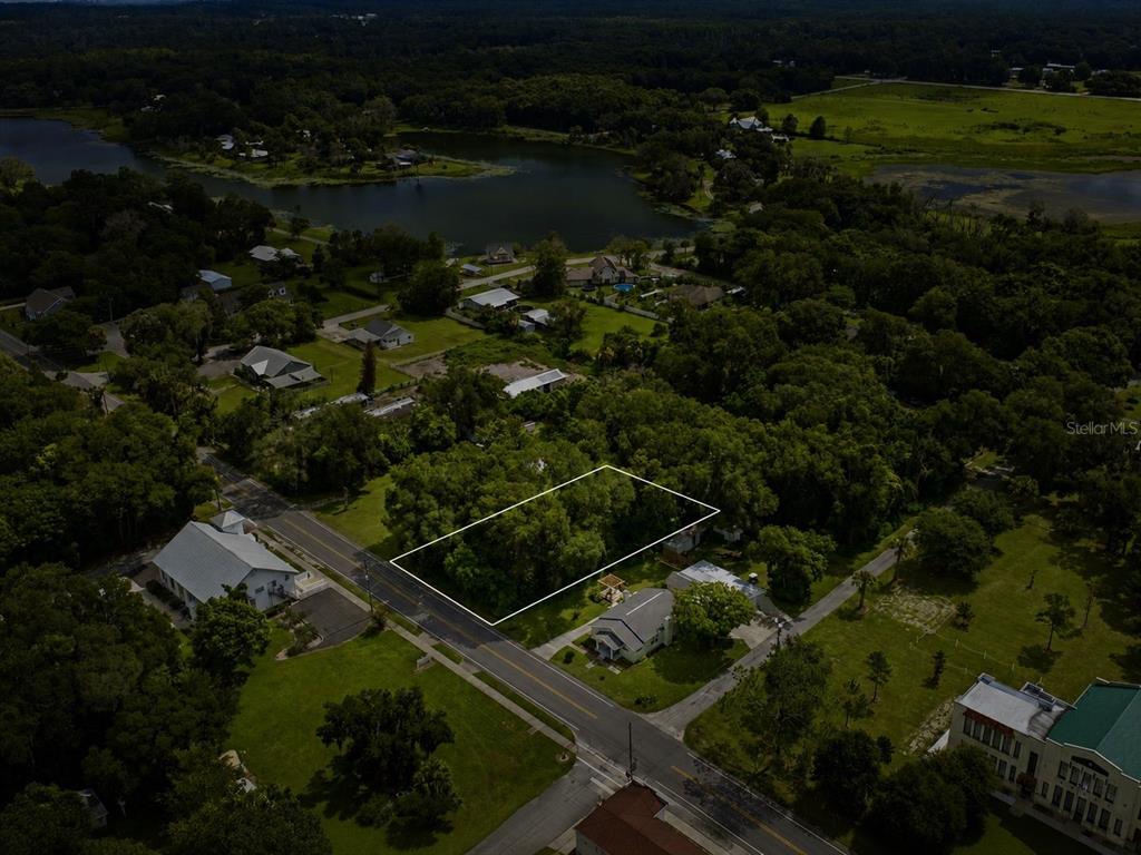 An aerial view shows a rectangular, tree-covered vacant lot outlined in white along a road — S LAKEVIEW DRIVE, LAKE HELEN, FL