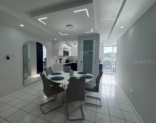 A dining area features a round table, modern chairs, and a recessed ceiling with lighting — A VISTA REAL UNIT 10, FAJARDO, PR