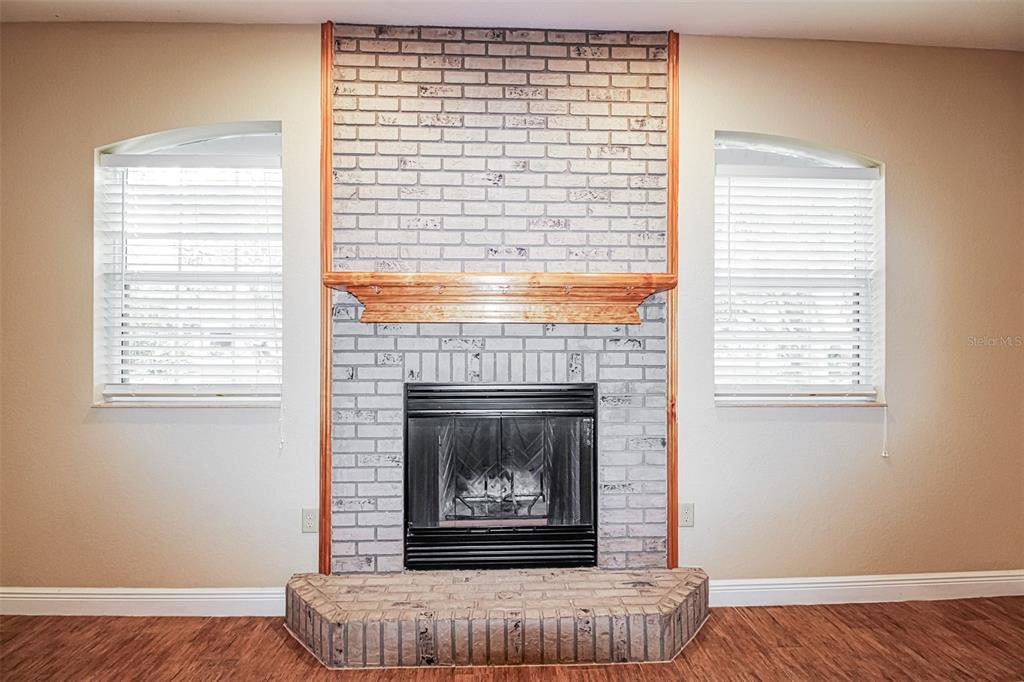 An empty room features hardwood floors, a ceiling fan, and a window with blinds — 13768 RUDI LOOP, SPRING HILL, FL