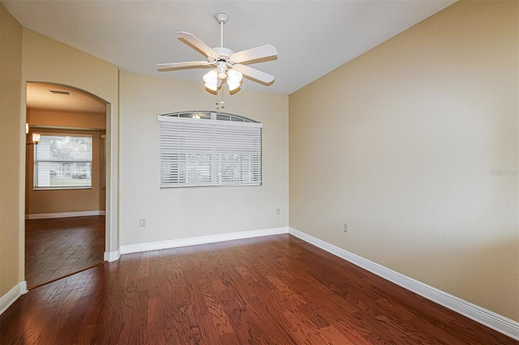 A living room features a gray sofa, two armchairs, and a brick fireplace with television — 13768 RUDI LOOP, SPRING HILL, FL
