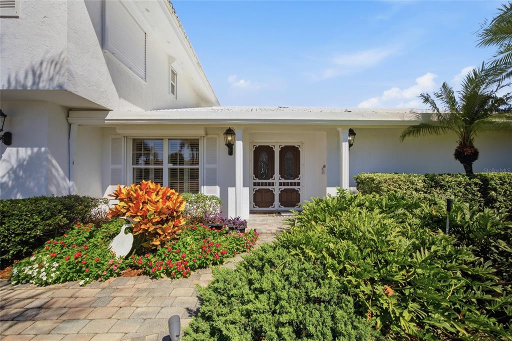 A white house exterior features a paved walkway leading to a double front door — 4912 58TH AVENUE S, ST PETERSBURG, FL