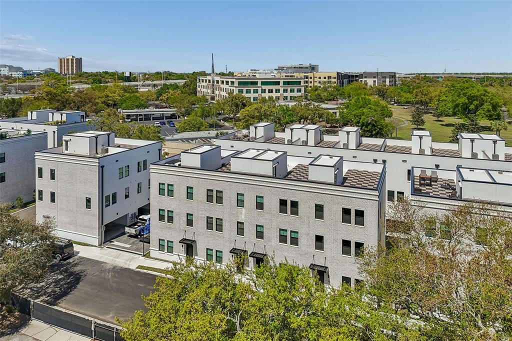 An aerial view shows a multi-story white brick townhouse complex with flat roofs and balconies — 1218 E KAY STREET UNIT 18, TAMPA, FL
