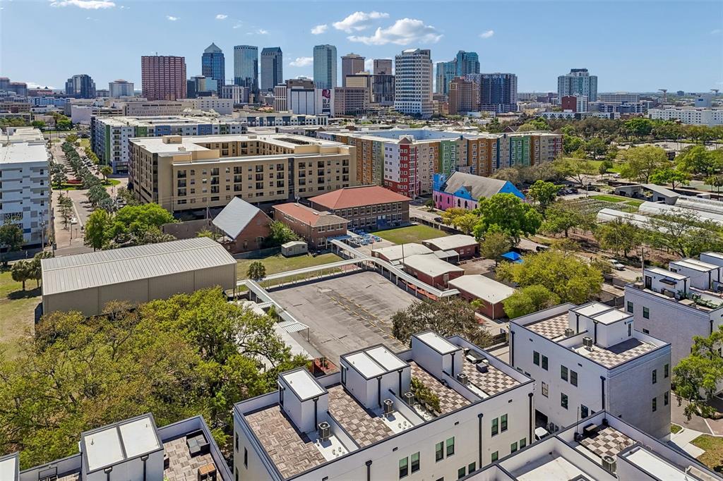 An aerial view shows a city skyline behind a complex of buildings and parking lots — 1218 E KAY STREET UNIT 18, TAMPA, FL