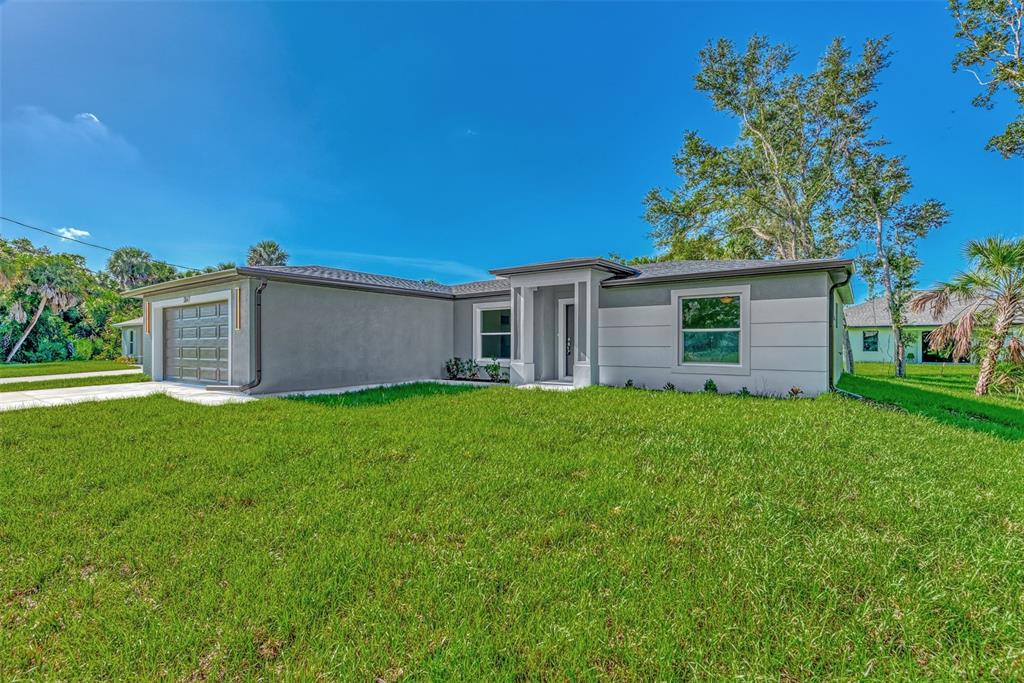 A single-story house with a gray stucco exterior, a garage, and a front entrance — 4582 ENID LANE, NORTH PORT, FL