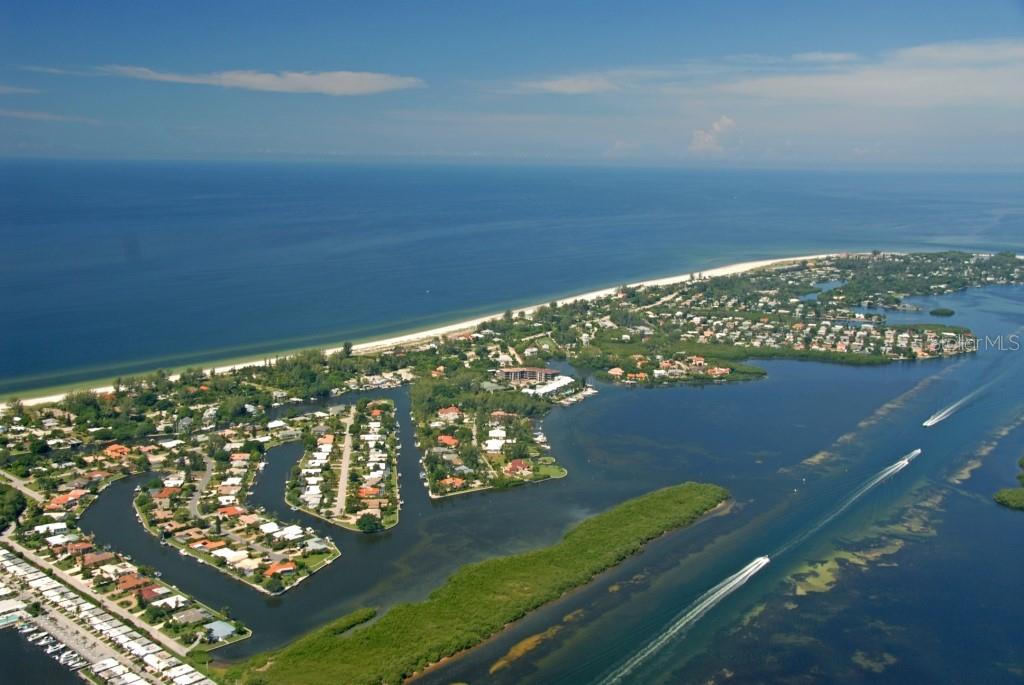 Aerial view of a coastal residential neighborhood with canals, a beach, and the ocean — 6700 GULF OF MEXICO DRIVE UNIT 118, LONGBOAT KEY, FL