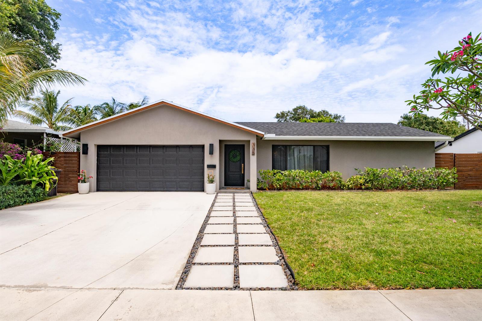 A single-story house with a gray exterior, a dark garage door, and a paved walkway — 335 Franklin Road, West Palm Beach FL 33405, WEST PALM BEACH, FL
