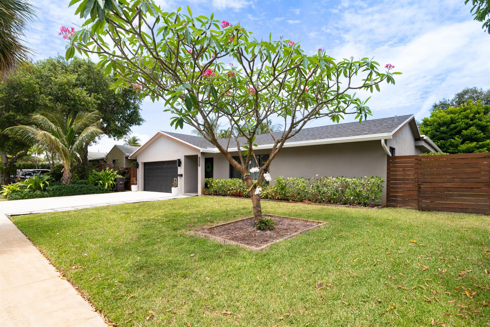 A single-story house with a gray exterior, a dark garage door, and a flowering tree — 335 Franklin Road, West Palm Beach FL 33405, WEST PALM BEACH, FL