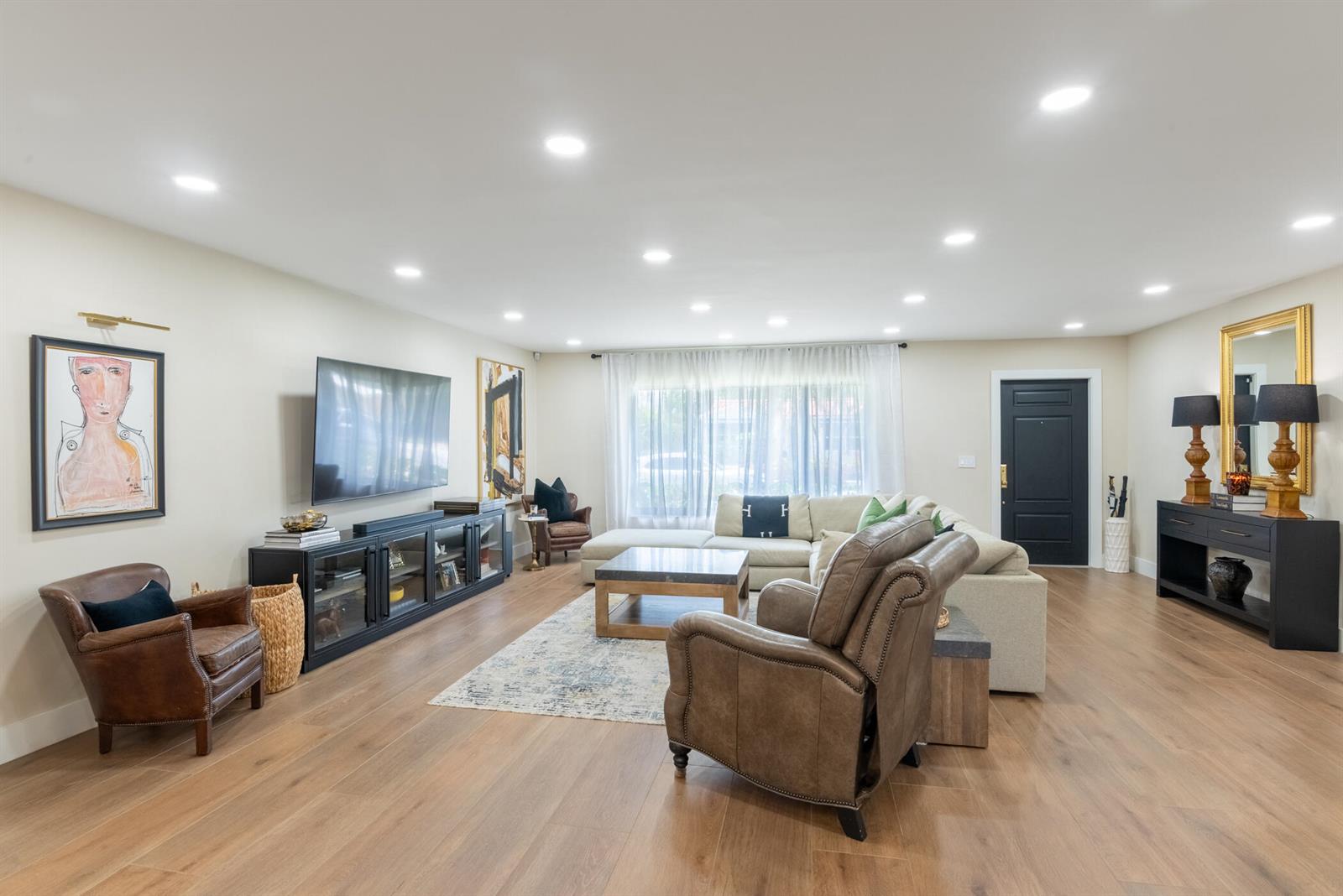 A living room features a sectional sofa, leather armchairs, a television, and wood flooring — 335 Franklin Road, West Palm Beach FL 33405, WEST PALM BEACH, FL