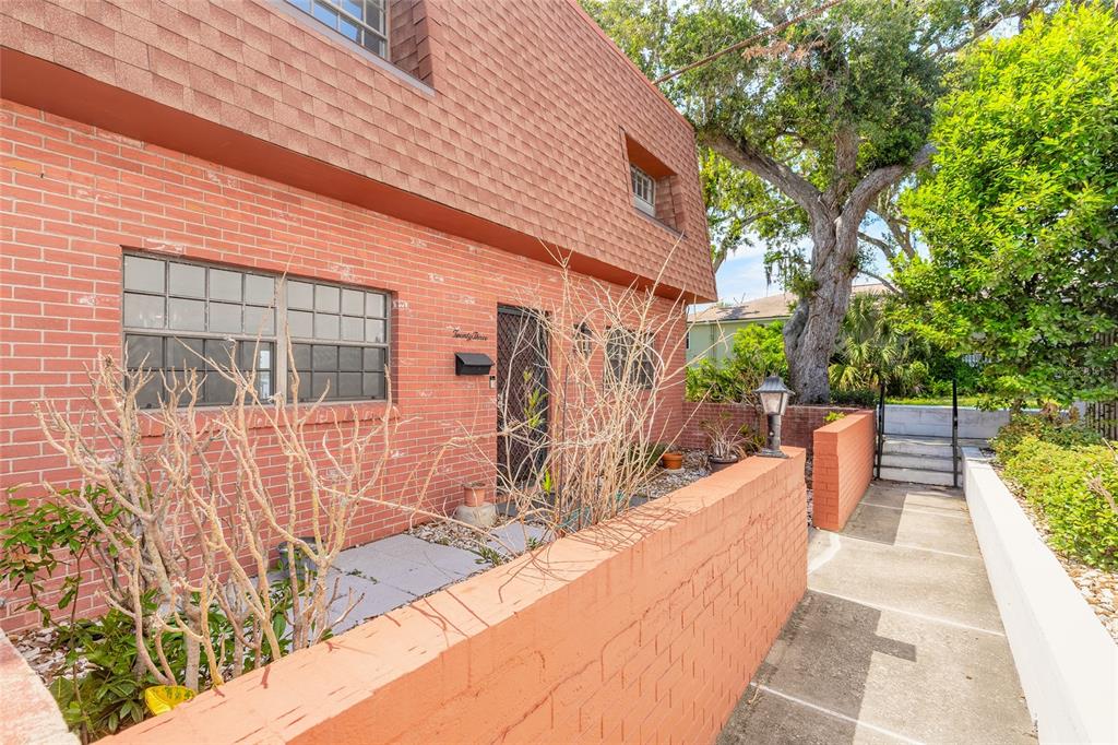 A brick exterior of a two-story building with a front walkway and a low wall — 625 N HALIFAX AVENUE UNIT 23, DAYTONA BEACH, FL