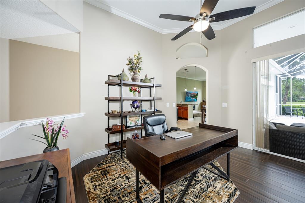 A home office features a dark wood desk, a bookshelf, and a ceiling fan — 5429 BURNT HICKORY DRIVE, VALRICO, FL