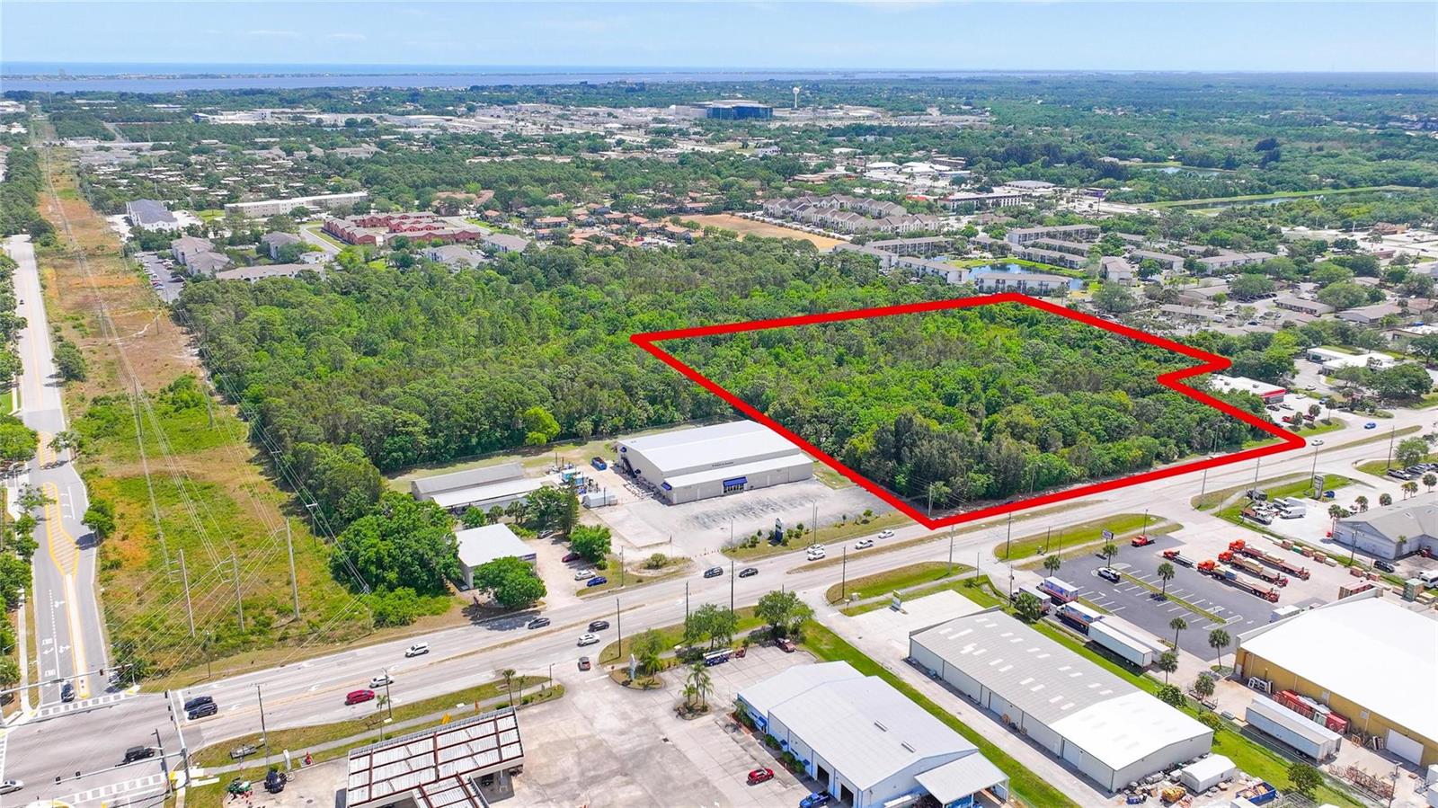 An aerial view shows a large, wooded plot of land outlined in red near commercial buildings — 4527 S Babcock Street, Palm Bay FL 32905, PALM BAY, FL
