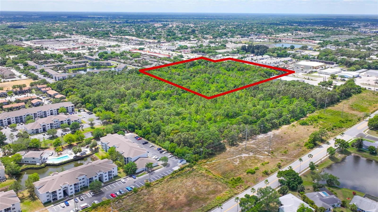 An aerial view shows a large, wooded plot of land outlined in red near residential buildings — 4527 S Babcock Street, Palm Bay FL 32905, PALM BAY, FL