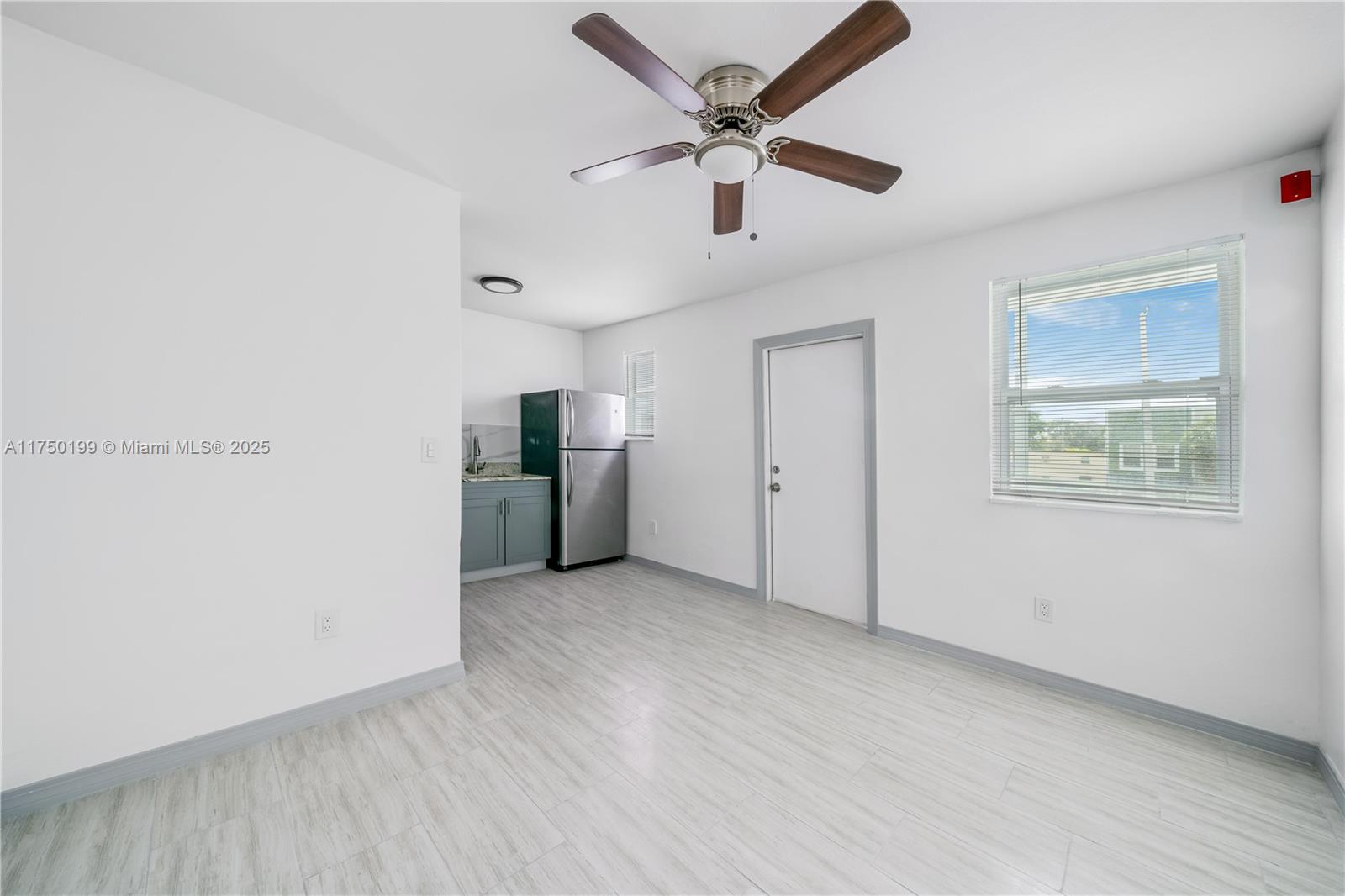 A room with white walls, light wood-look flooring, a ceiling fan, and a kitchenette — 1281 NW 61st St # 2, Miami FL 33142, MIAMI, FL