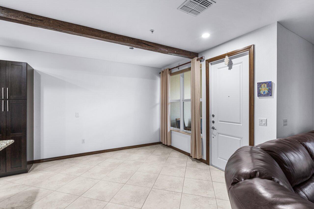 A room with tile flooring, a wooden ceiling beam, a window, and a white door — 1511 NW 48th Lane, Boca Raton FL 33431, BOCA RATON, FL