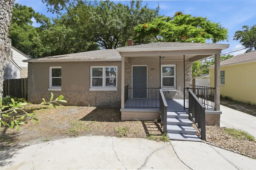 A single-story house with a stone-accented facade, a front porch, and a concrete driveway — 1416 E MOHAWK AVENUE, TAMPA, FL
