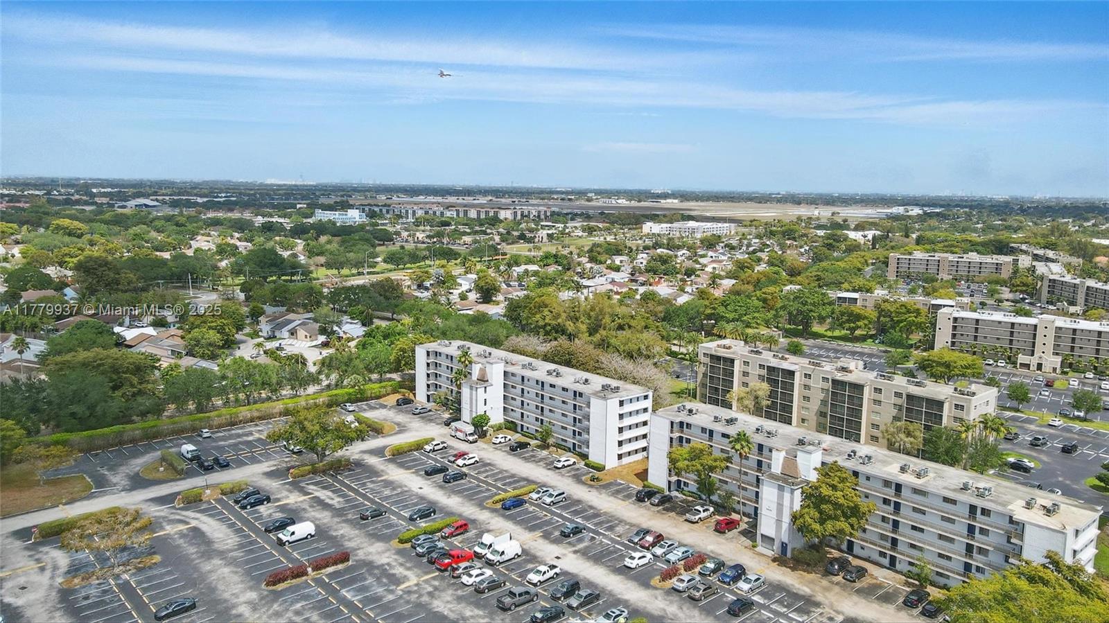 An aerial view shows two multi-story apartment buildings surrounded by a large parking lot — 8540 N Sherman Cir # 408, Miramar FL 33025, MIRAMAR, FL