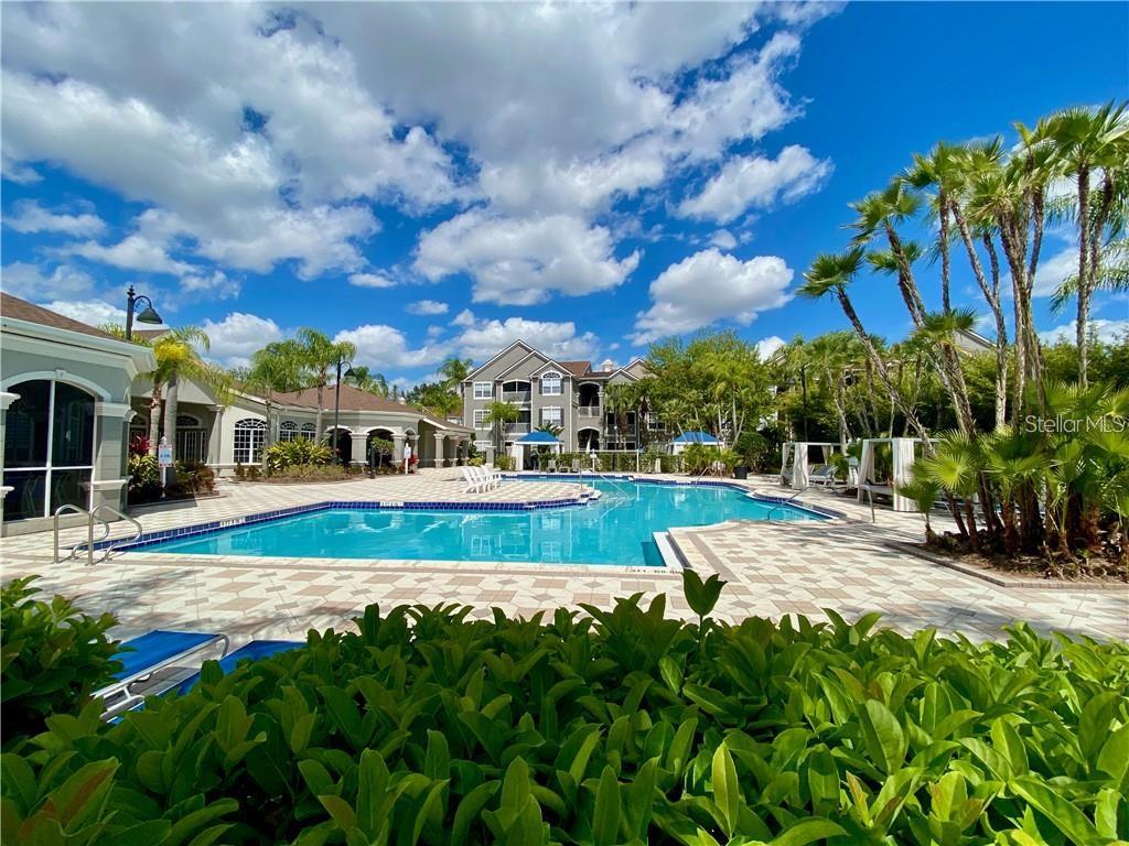 A swimming pool sits in front of a multi-story apartment building with palm trees — 3307 S KIRKMAN ROAD UNIT 123, ORLANDO, FL