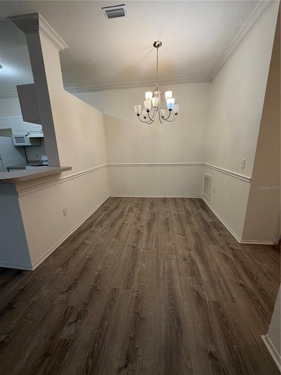 A dining area with wood-look flooring, a chandelier, and white walls with chair rail molding — 3307 S KIRKMAN ROAD UNIT 123, ORLANDO, FL