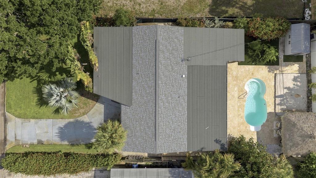 An aerial view shows a house with a gray roof, a backyard pool, and landscaping — 3947 HUNTINGTON STREET NE, ST PETERSBURG, FL