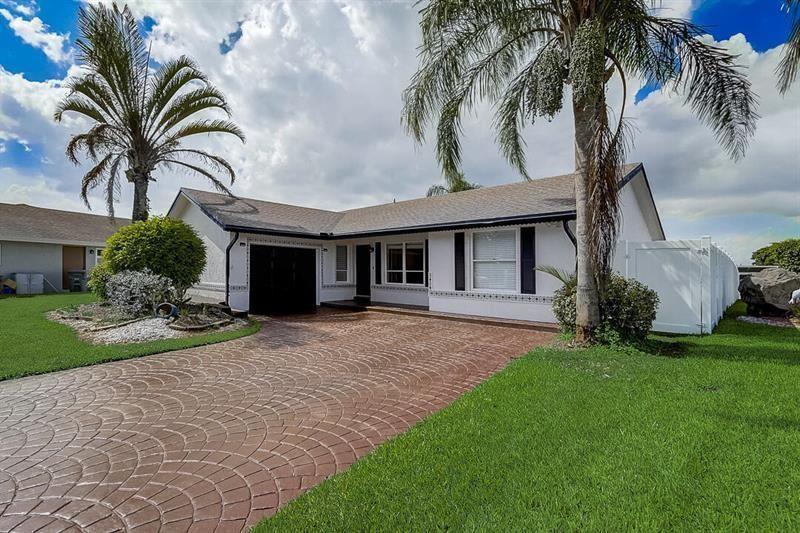 A single-story white house features a stamped concrete driveway, a garage, and two palm trees — 9387 Richmond Circle, Boca Raton FL 33434, BOCA RATON, FL