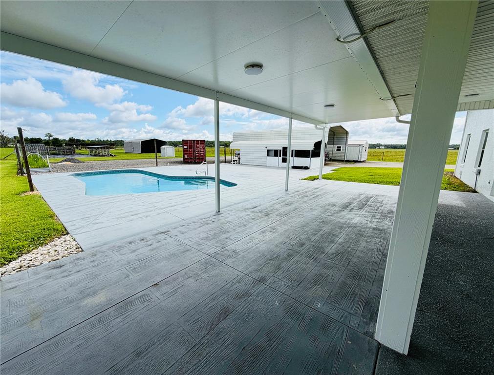 A single-story house with a metal roof, a covered porch, and a large front lawn — 9120 COUNTY ROAD 304, BUNNELL, FL