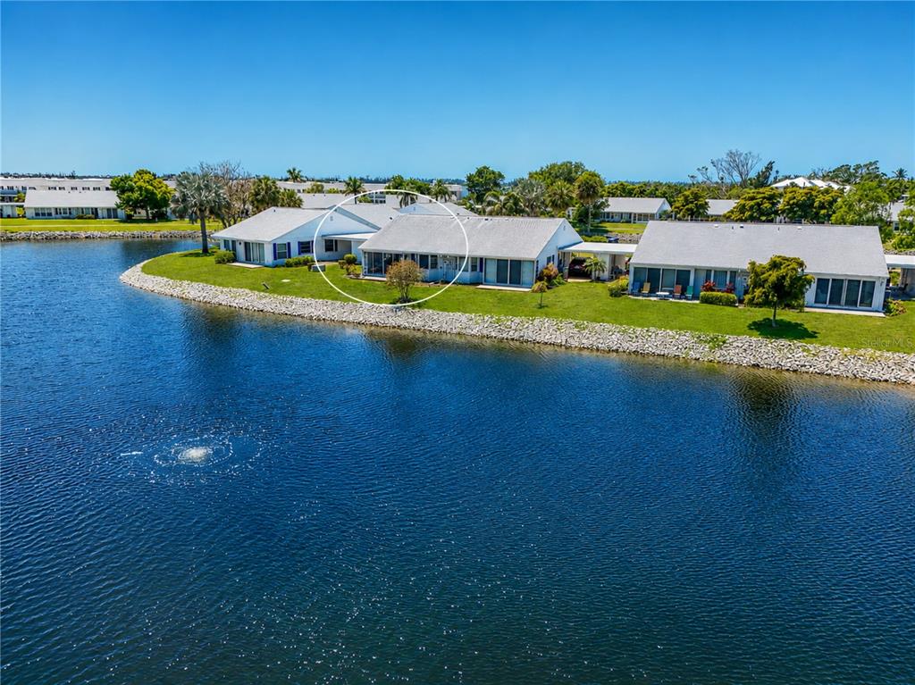 An aerial view shows a waterfront residential building with a white circle highlighting a unit — 4603 LEXINGTON CIRCLE, BRADENTON, FL