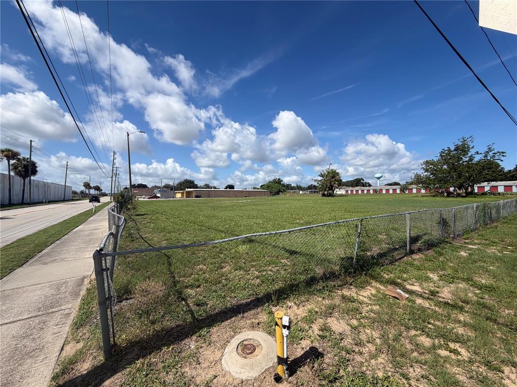 A fenced, vacant grassy lot sits next to a sidewalk and a paved road — 540 S SCENIC HIGHWAY, FROSTPROOF, FL