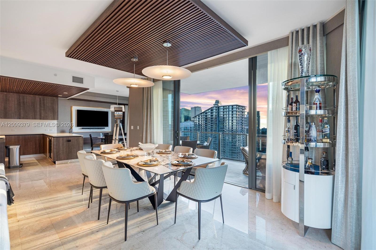 A modern dining room features a marble table, slatted wood ceiling, and a city balcony view — 88 SW 7th St # 3801, Miami FL 33130, MIAMI, FL