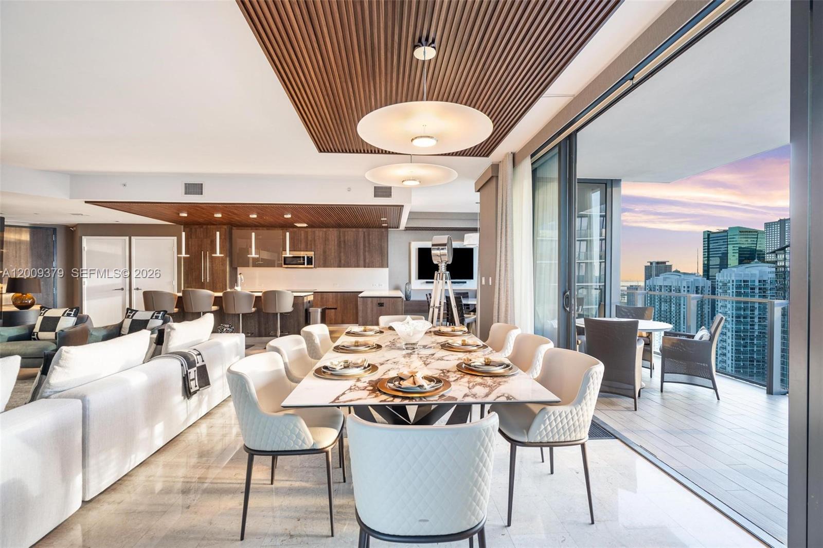A modern open-plan dining and living area features a marble table and a balcony view — 88 SW 7th St # 3801, Miami FL 33130, MIAMI, FL