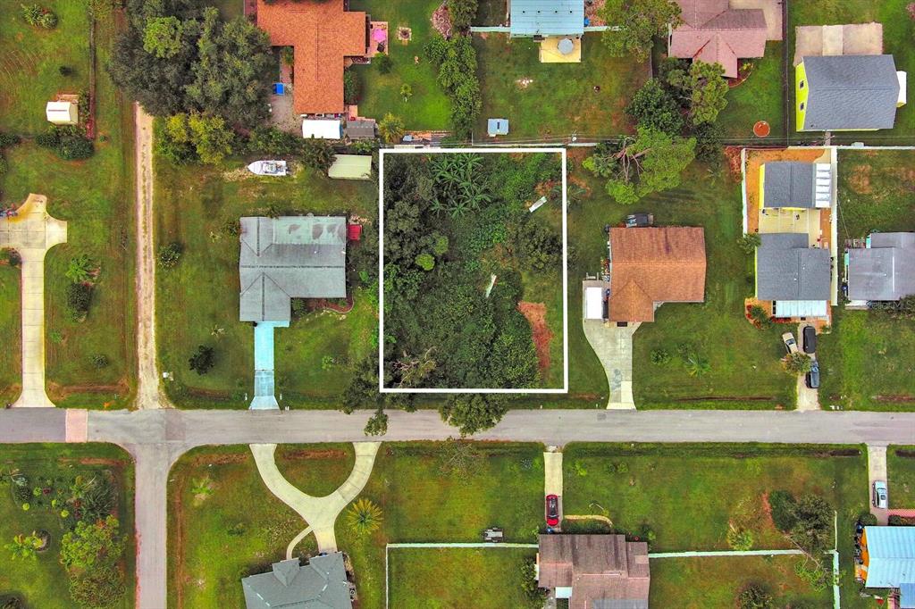An aerial view shows a vacant, wooded rectangular lot situated between two residential houses — GILLESPIE STREET, ENGLEWOOD, FL