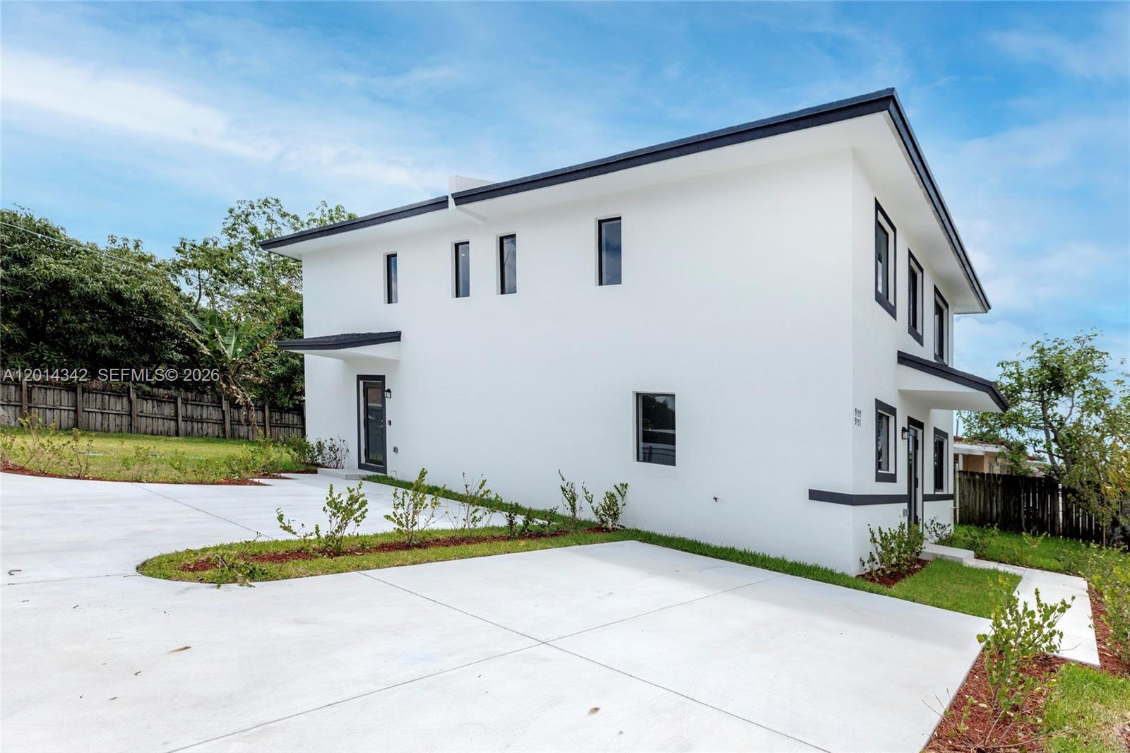 A two-story white modern house features black window frames and a concrete driveway — 9155 NW 32 Ave, Miami FL 33147, MIAMI, FL