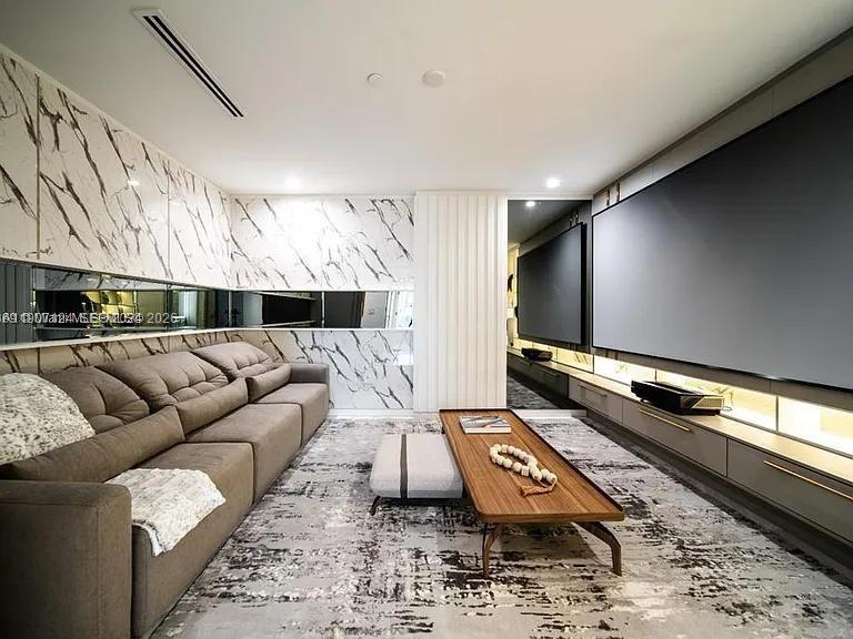 A modern living room features a large gray sofa, marble walls, and a wooden coffee table — 851 NE 1st Ave # 4811, Miami FL 33132, MIAMI, FL