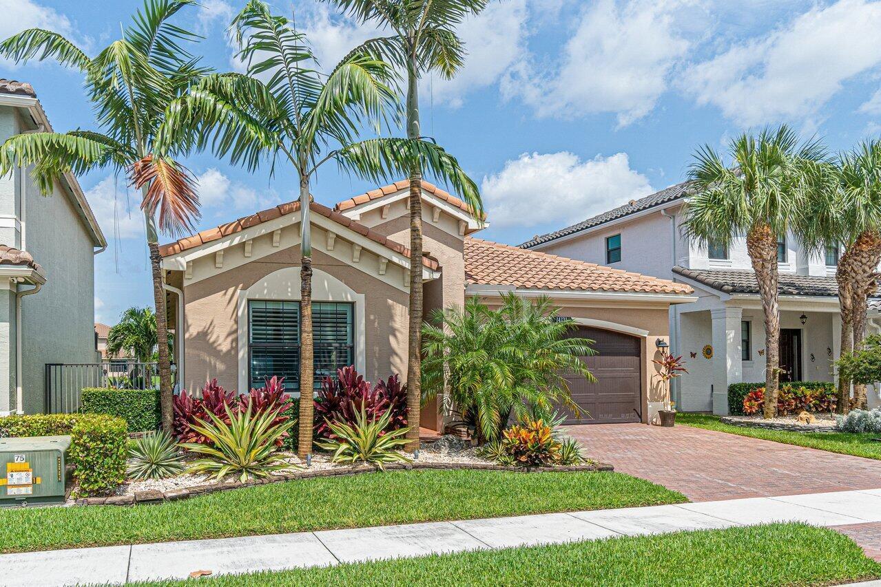 A single-story tan house with a tile roof, palm trees, and a brick driveway — 14131 Rock Salt Road, Delray Beach FL 33446, DELRAY BEACH, FL