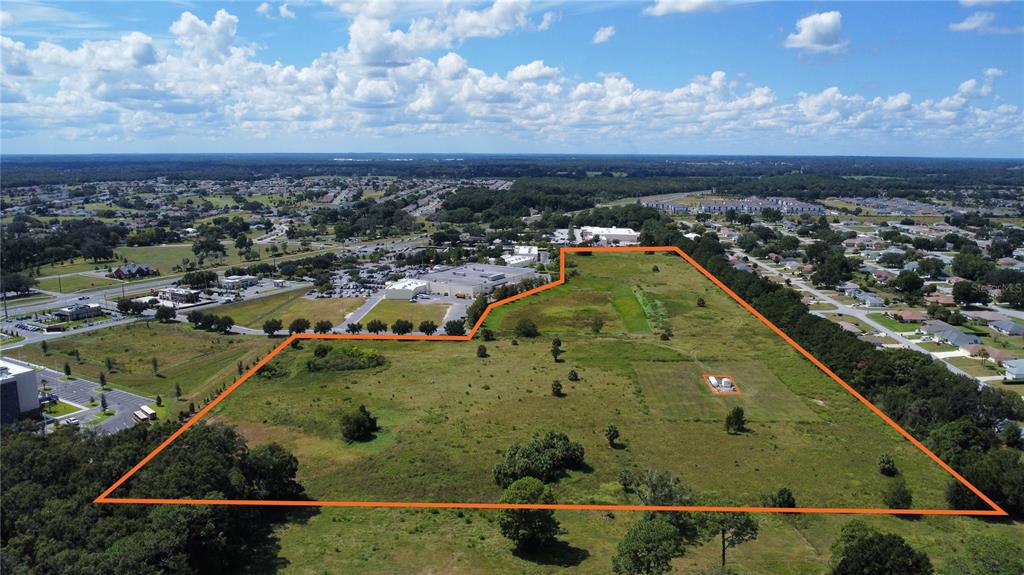 An aerial view shows a large, undeveloped grassy lot outlined in orange — 2785 NW 49TH AVENUE, OCALA, FL