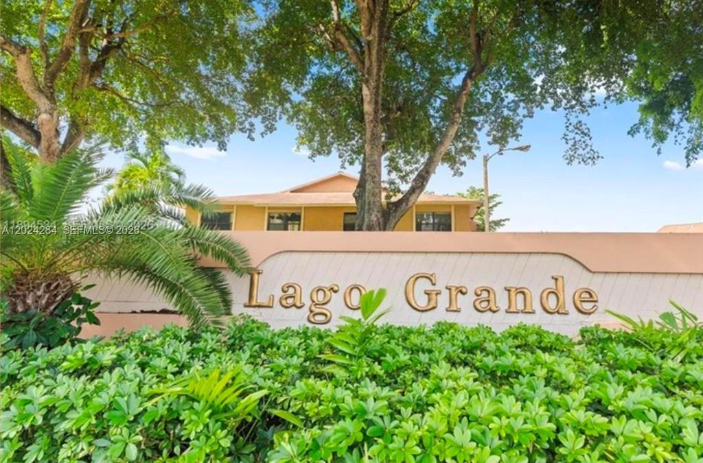 A sign for Lago Grande stands in front of a building and lush green foliage — 6575 W 27th Court # 46, Hialeah FL 33016, HIALEAH, FL