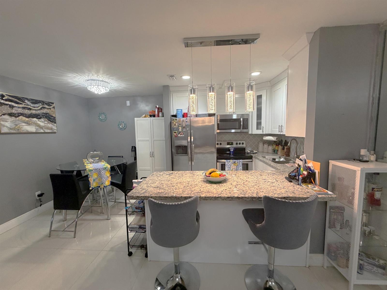 A kitchen with granite countertops, stainless steel appliances, and a dining area with gray walls — 6575 W 27th Court # 46, Hialeah FL 33016, HIALEAH, FL