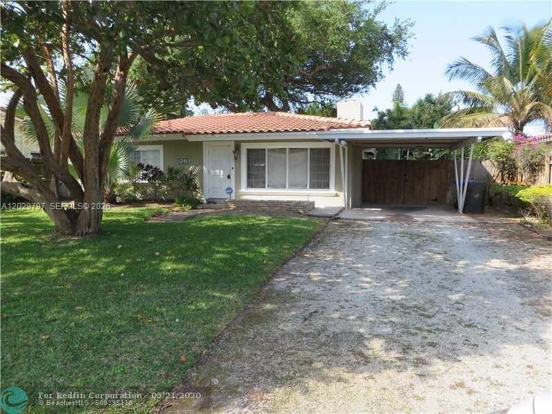 A single-story house with a tiled roof, a front lawn, and an attached carport — FORT LAUDERDALE, FL