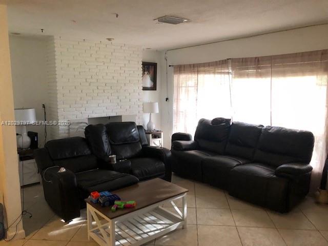A living room features a white brick fireplace, black leather sofas, and a wooden coffee table — FORT LAUDERDALE, FL