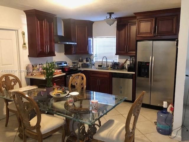 A kitchen features dark wood cabinets, stainless steel appliances, and a glass dining table — FORT LAUDERDALE, FL