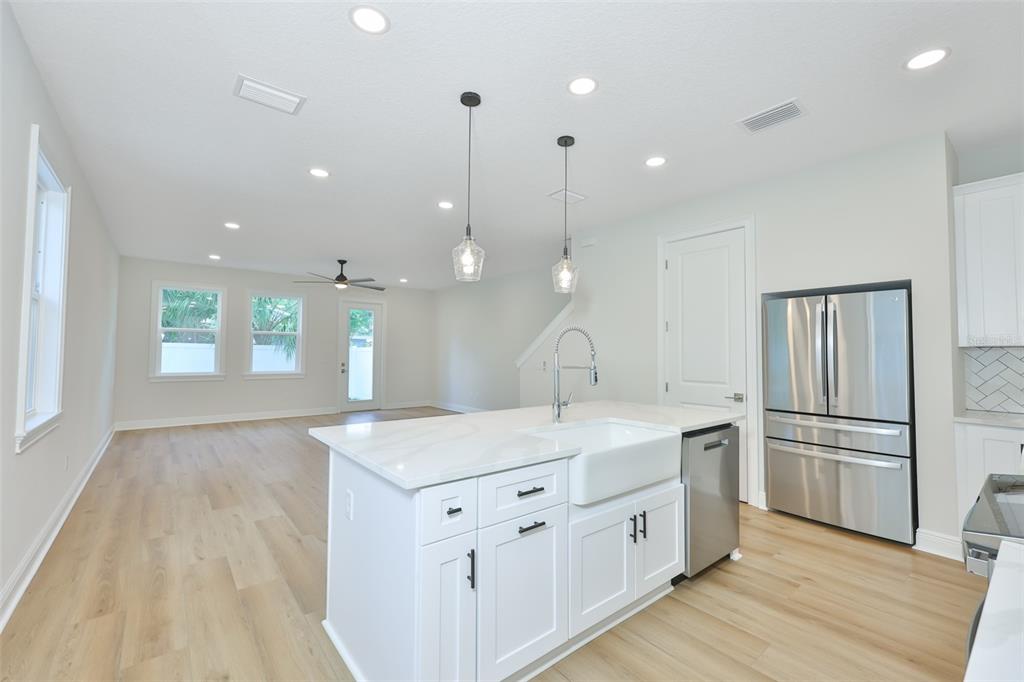 A modern kitchen features a white island with a farmhouse sink and stainless steel appliances — 1913 W BEACH STREET, TAMPA, FL