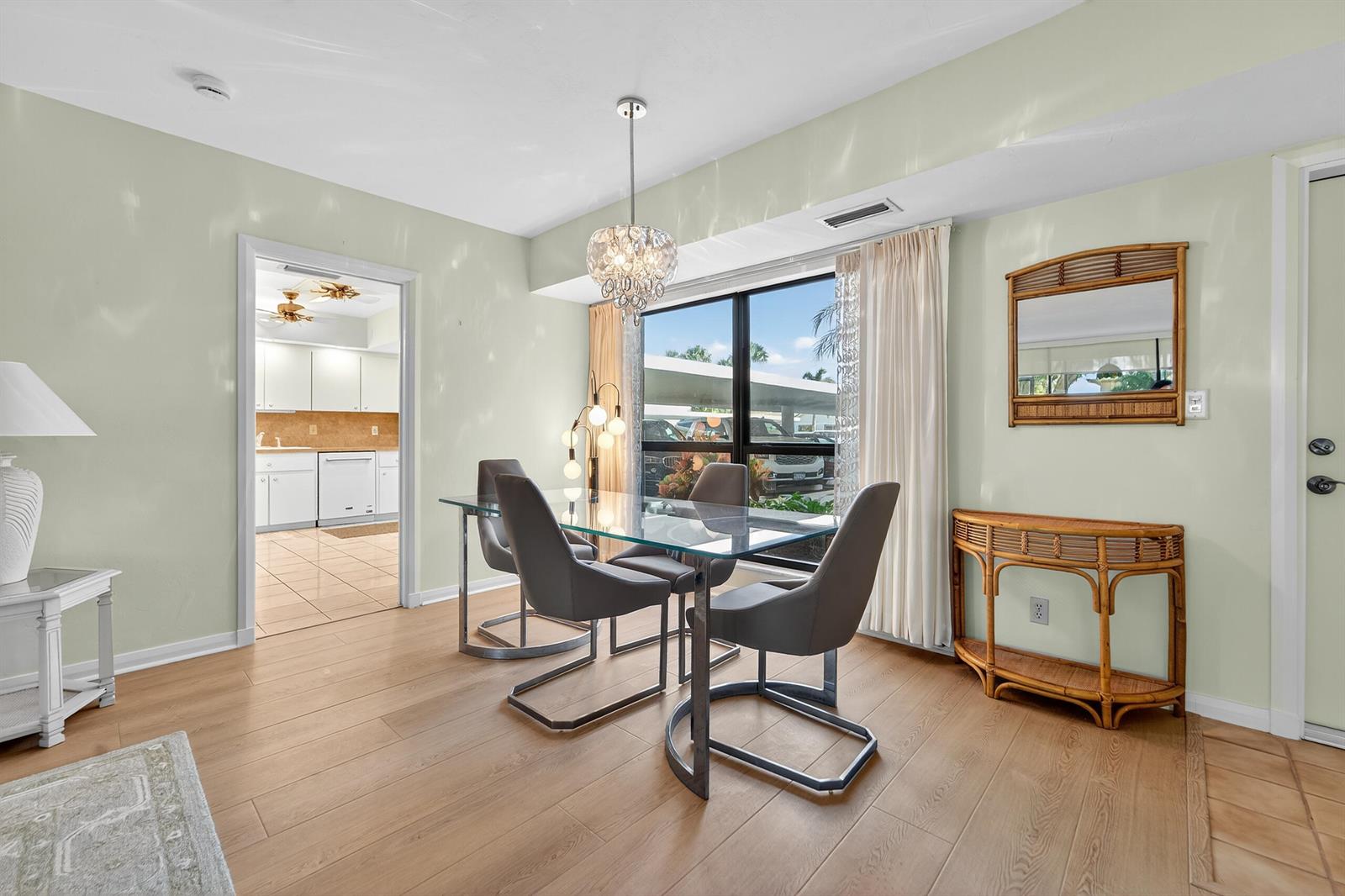 A dining room features a glass table, four gray chairs, and a rattan console table — 6 Concourse Drive # A, Jupiter FL 33469, JUPITER, FL