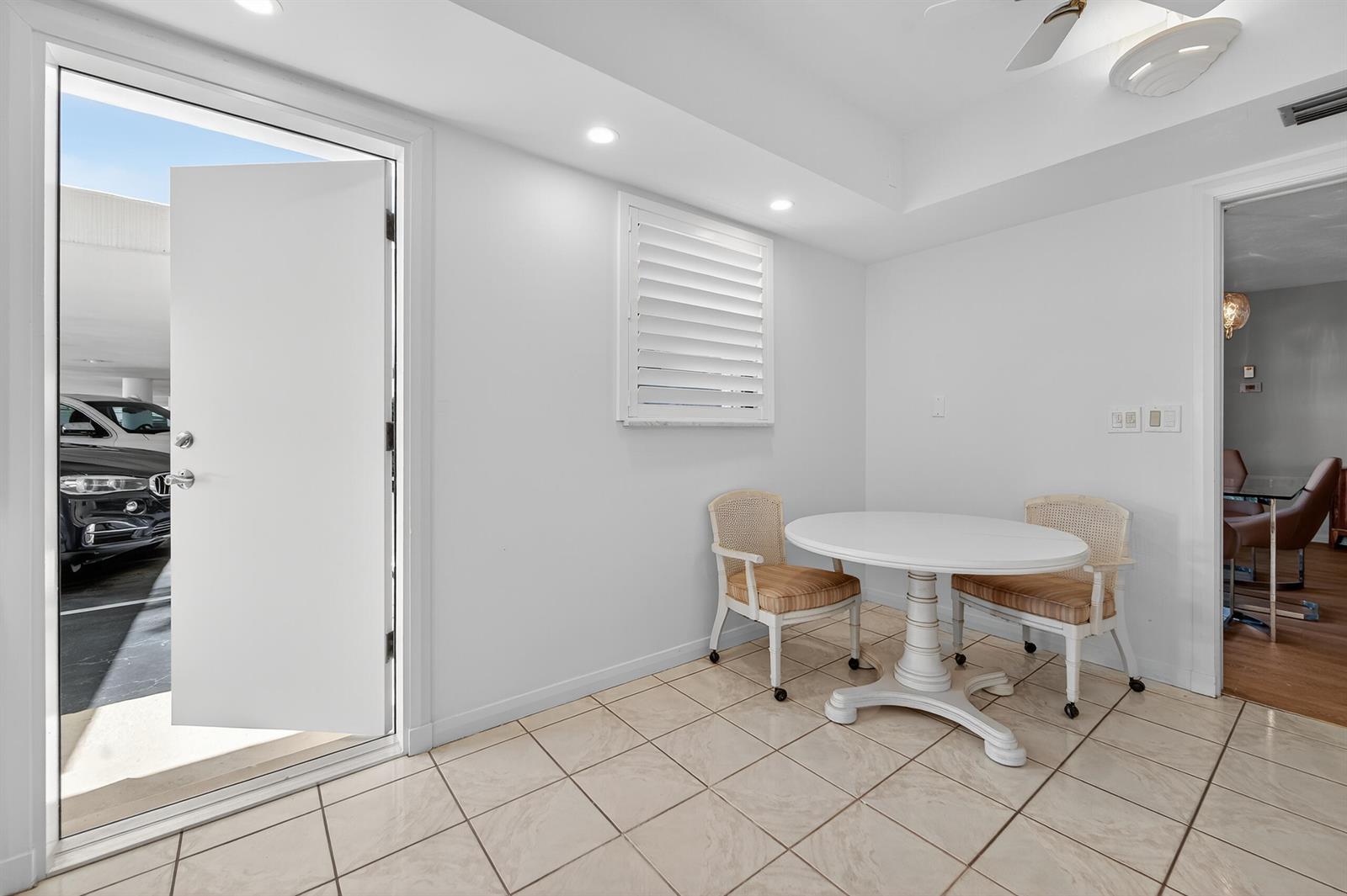 A small dining area with a round white table, two chairs, and tiled flooring — 6 Concourse Drive # A, Jupiter FL 33469, JUPITER, FL