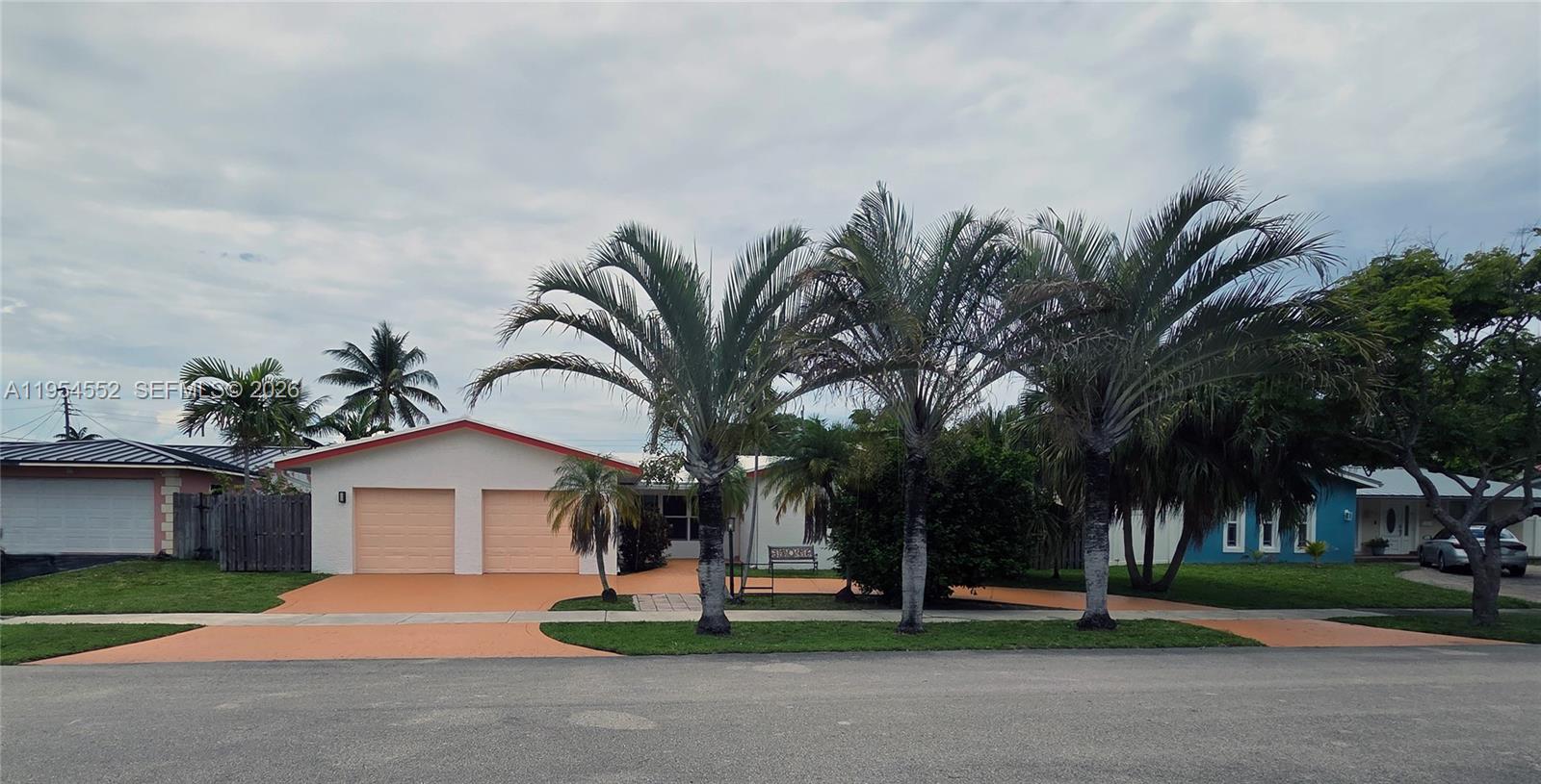 A single-story house with a two-car garage and palm trees in the front yard — 1245 Coral Ln, Hollywood FL 33019, HOLLYWOOD, FL