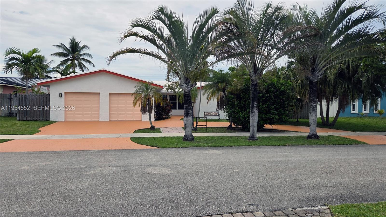 A single-story house with a two-car garage and palm trees in the front yard — 1245 Coral Ln, Hollywood FL 33019, HOLLYWOOD, FL