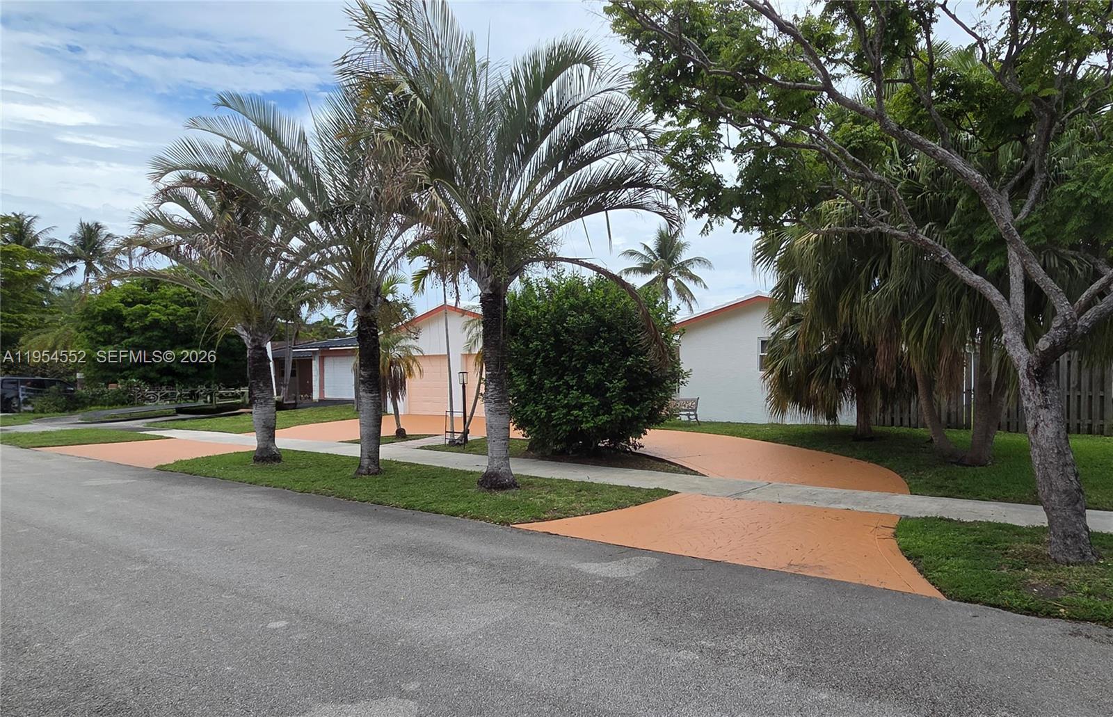A single-story house with a peach-colored driveway and palm trees in the front yard — 1245 Coral Ln, Hollywood FL 33019, HOLLYWOOD, FL