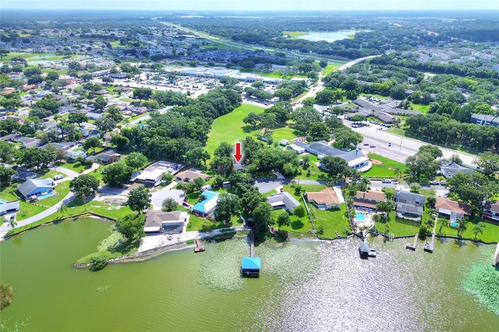 An aerial view shows a waterfront house with a dock, surrounded by trees and neighborhood homes — 5315 POST LANE, LAKELAND, FL