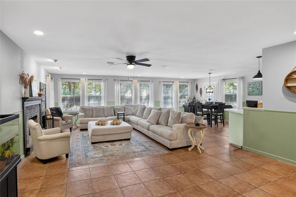 A spacious living room features a large sectional sofa, tile flooring, and a stone fireplace — 5315 POST LANE, LAKELAND, FL