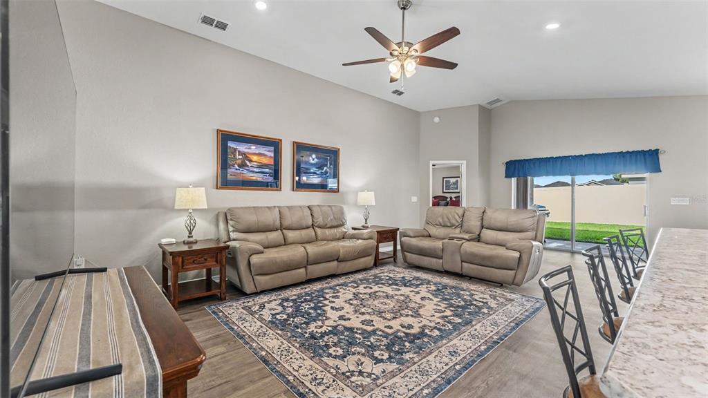 A living room features a large area rug, two leather sofas, and a ceiling fan — 3863 WILLOW RIDGE DRIVE, LAKELAND, FL