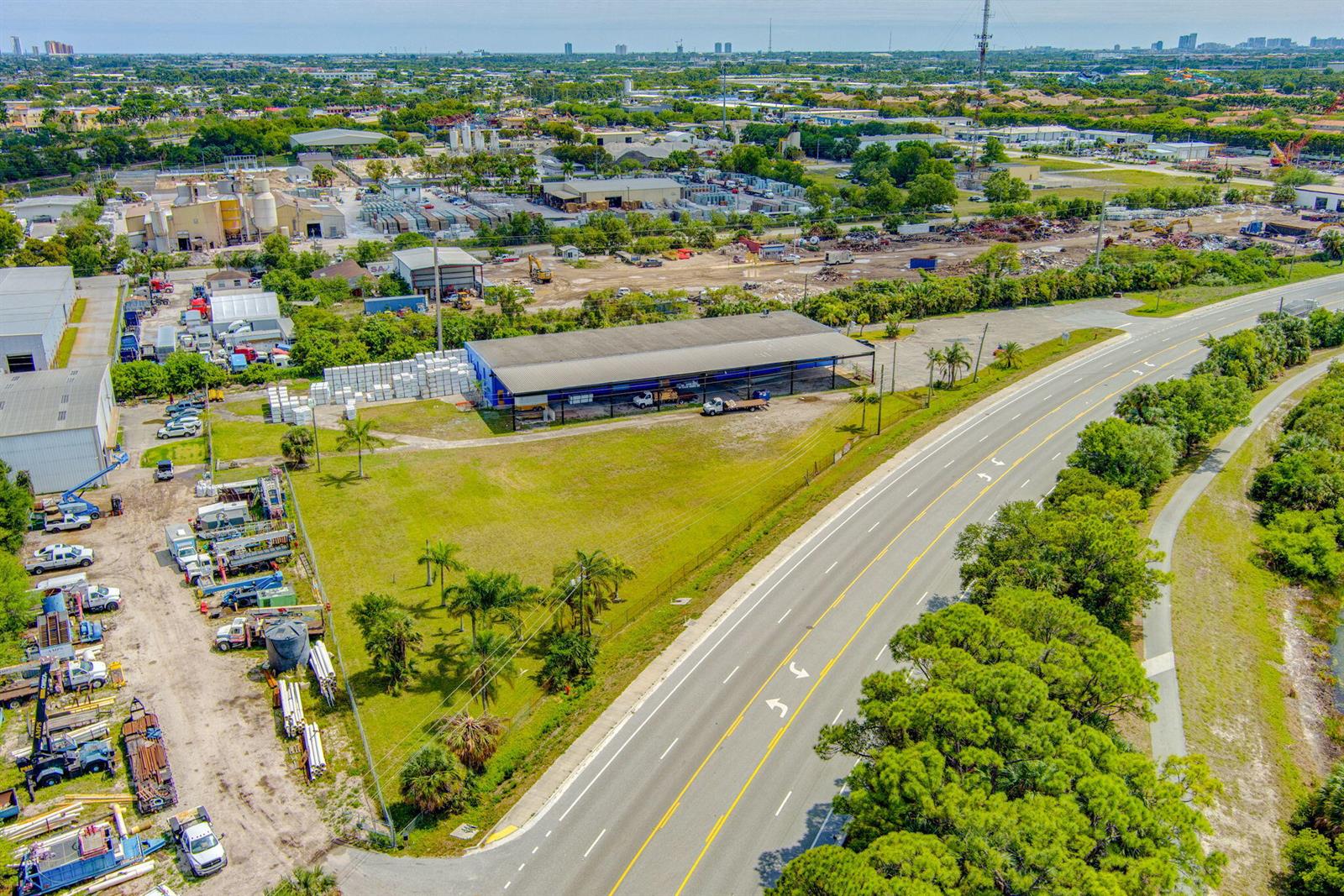 An aerial view shows a commercial warehouse building with an adjacent lot and a road — 7030 Haverhill Road, Riviera Beach FL 33407, RIVIERA BEACH, FL
