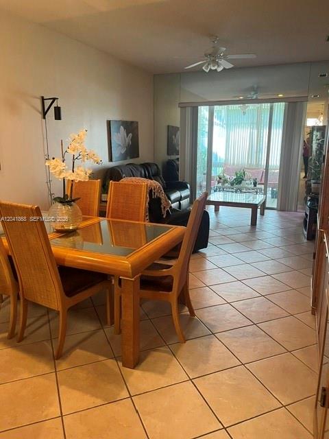 A dining area with a glass-topped table and wicker chairs sits before a living room — 10136 Lombardy Dr, Tamarac FL 33321, TAMARAC, FL